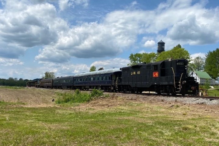 a train on a track near a grassy field